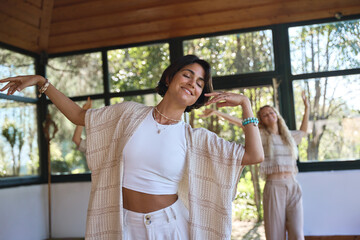 Happy young women community dancing moving together during spiritual practice meditation experience...