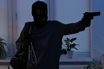 Thief with gun stealing jewels in foreign house. Burglary