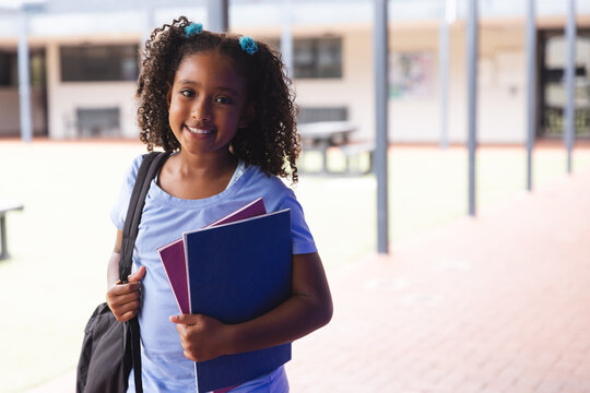 Biracial girl smiling at school, with copy space - Powered by Adobe