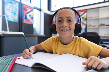 Biracial boy studies in a classroom at school