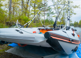 Inflatable PVC boat catamaran for fishing and hunting preparation. Vacation and leisure. Inflatable dinghy vessel or air-filled craft pontoon with electric motor and lithium battery.