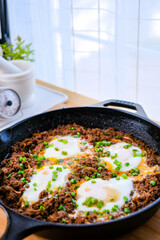Homemade egg with ground beef in the cast iron pan. Cooking asian foo concept.