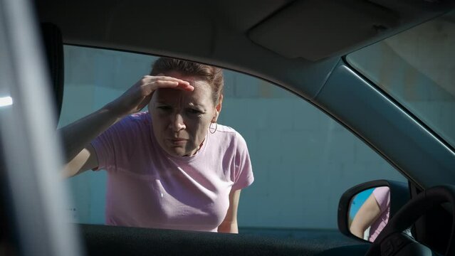 Car thief look into car window. A view of strange female car thief look into the auto window during day time.