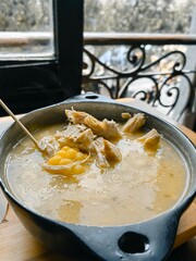 Traditional Colombian ajiaco soup close up in a bowl on the table. horizontal view from above