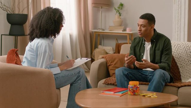 African American woman man consultation doctor appointment psychologist mental health write clipboard notes conversation healthcare patient talk visit speaking medicine therapy help advice female male