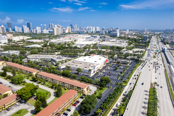 Aventura, Florida, USA - Aerial of apartment blocks and strip malls, with skyline of Sunny Isles...