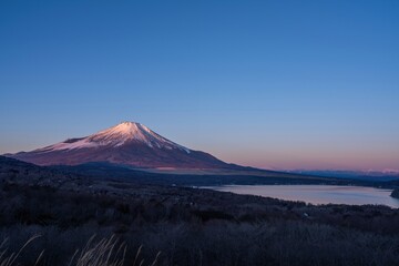 Fototapeta premium 展望台から見た朝日を浴びて輝く富士山と山中湖のコラボ情景