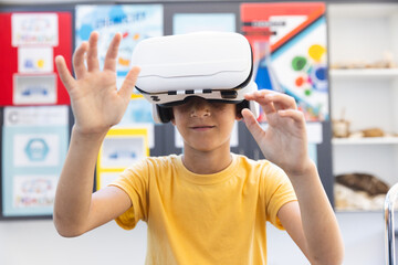 Biracial boy explores virtual reality in a classroom at school