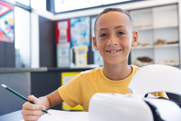 Biracial boy smiles while studying at school