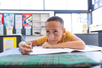 Biracial boy focuses on his schoolwork at school