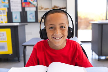 Biracial boy studies in a classroom at school on a video call