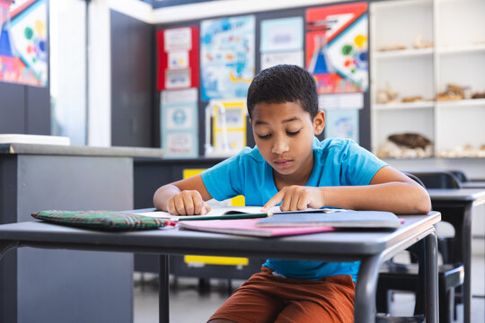 Biracial boy focused on schoolwork in a classroom at school