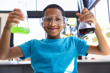 Biracial boy enjoys a science experiment at school in the classroom