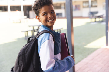 Biracial boy smiles at school, with copy space