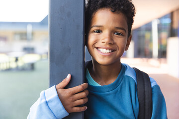 Biracial boy smiles at school, with copy space