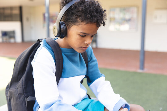 Biracial boy listens to music at school, with copy space - Powered by Adobe