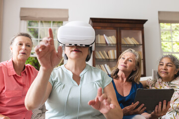 Diverse senior female friends exploring virtual reality at home