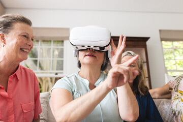 Diverse senior female friends are exploring virtual reality at home