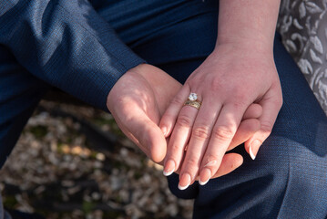 The groom holds the bride's hand. Newly wed couple's hands with wedding rings ,in Romania