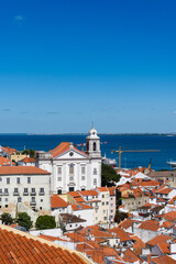 Fototapeta premium View of the beautiful skyline of Lisbon, Portugal, with red roofed, colorful houses in the Alfama district during a sunny day