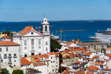 Fototapeta premium View of the beautiful skyline of Lisbon, Portugal, with red roofed, colorful houses in the Alfama district during a sunny day