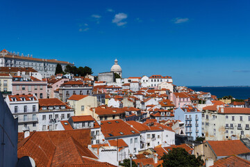 Fototapeta premium View of the beautiful skyline of Lisbon, Portugal, with red roofed, colorful houses in the Alfama district during a sunny day