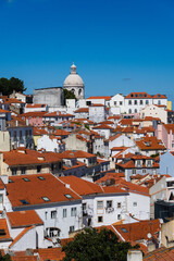 View of the beautiful skyline of Lisbon, Portugal, with red roofed, colorful houses in the Alfama district during a sunny day