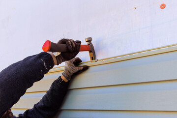 Damaged plastic siding of house is replaced during reconstruction of its exterior