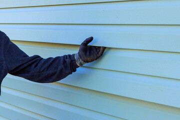 During exterior house remodel reconstruction of house, damaged plastic siding is replaced