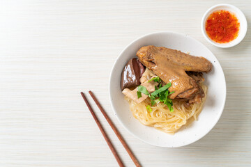 dried noodles with braised duck in white bowl