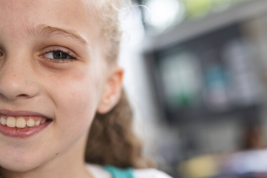 In school, young Caucasian girl is smiling with copy space in the classroom