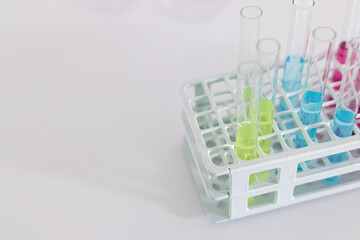 Test tubes with colorful liquids in a laboratory rack, with copy space