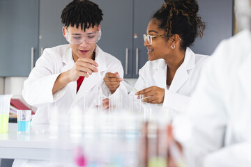 Teenage biracial students conduct an experiment in a high school lab