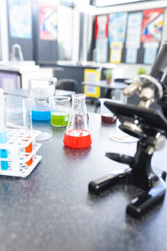 In school, colorful liquids in beakers and test tubes are sitting on lab bench