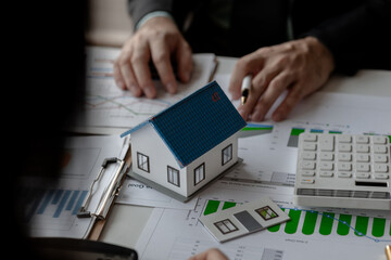 Fototapeta premium accommodation agency and client are planning together about finance because the client wanted to buy a house, meeting in property office with expert of how to find the best house for rent