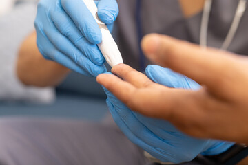 At home, young biracial male nurse assisting a senior female patient