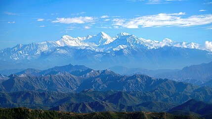 Fototapeta premium Majestic snow-capped mountain range under a blue sky with clouds
