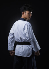 Asian master standing taekwondo uniform white black