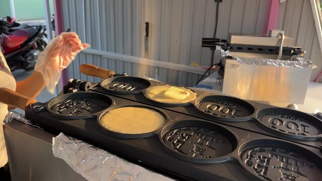 Street food vendor is preparing the dough and pan-frying paratha roti in hot oil until crispy on the outside.