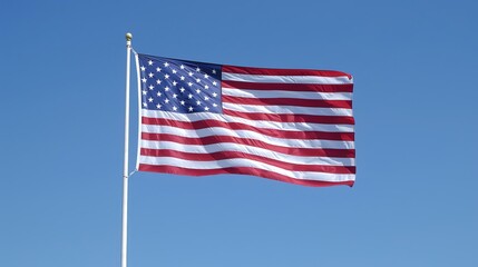 Fototapeta premium High resolution image of the American flag waving against a clear blue sky, symbolizing patriotism and national pride.