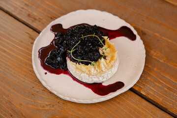 Baked Brie Topped with Blueberry Compote on Rustic Plate