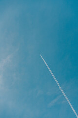 Plane leaving white trails in a clear blue sky