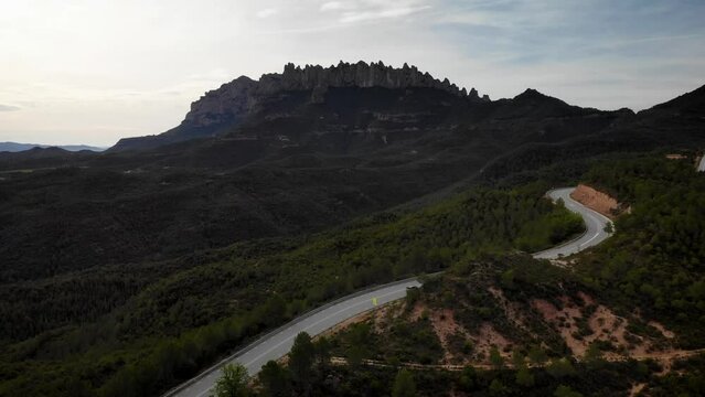 Mountain road with traffic pssing by at Montserrat mountain, Barcelona, Cataloia, Spain. High quality 4k drone view footage