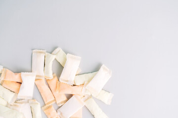 Lots of snus bags with fruit and mint flavors on a light background.