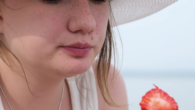 Accelerated video of a girl quickly eating strawberries, funny face of girl