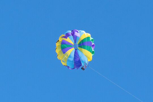 Parasailing on a sunny day. Parachuting above the clouds. Parasailing in a blue sky. Parachute walk on the sea