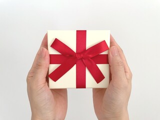 赤いリボンのプレゼントを持つ女性の手元
