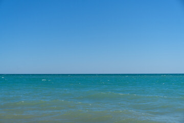 Obraz premium Blue sea waves. Wave splashing over pebbles at sea. Rolling ocean waves. Summer paradise beach background. Powerful sea waves