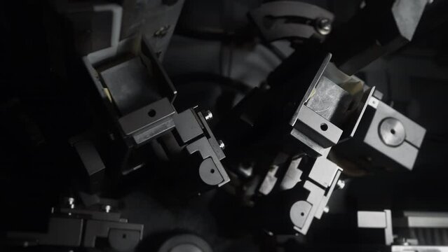 Automated cookie packaging machine mechanism in industrial factory close up.