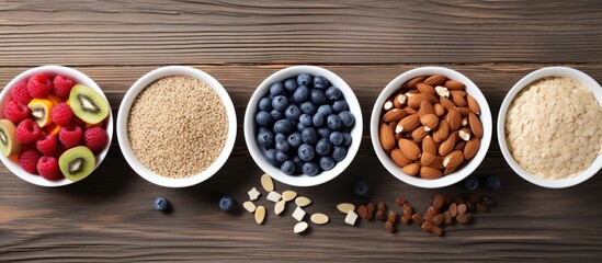 Top view of a bowl with homemade granola, yogurt, berries on a dark stone concrete background, alongside a cranberry and apple crumble topped with almond flakes and oat. Displaying a copy space image.